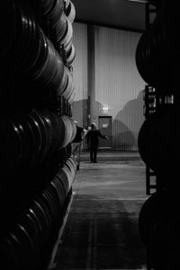 Frank Mitolo inspects wine barrels in the winery